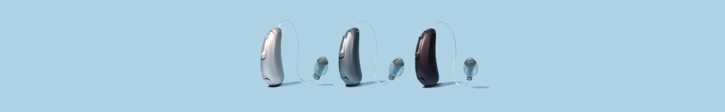 three hearing aids on a blue background