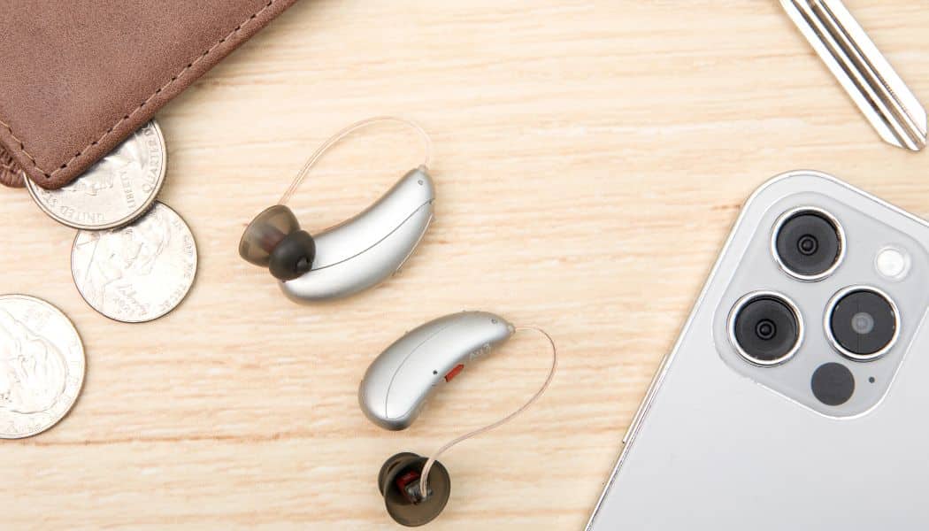 Hearing aids placed next to a phone and wallet